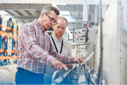 deux hommes qui regardent une machine industrielle