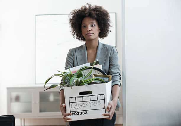 Jeune femme portant un carton avec ses affaires de bureau