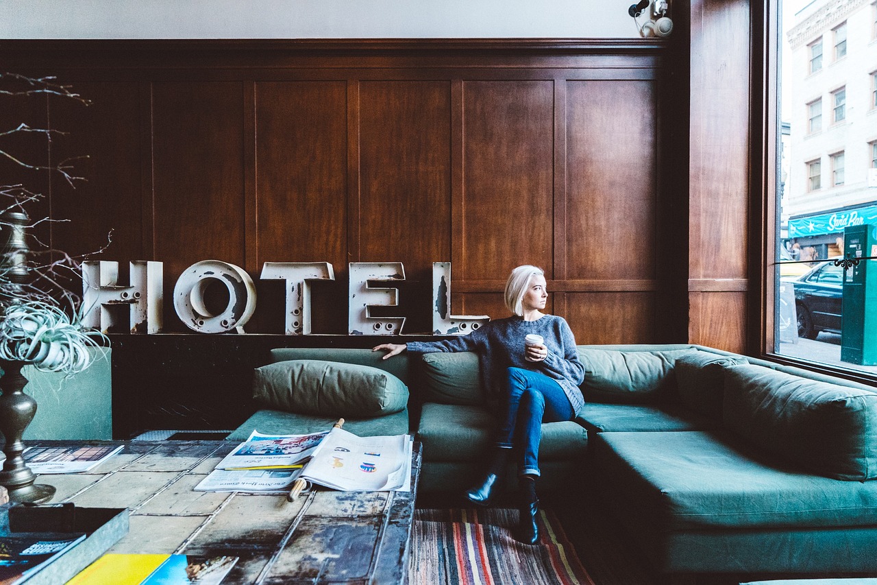 femme assise dans le salon d'un hôtel avec une tasse à la main