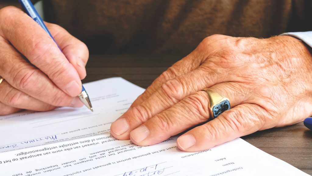 Vieil homme qui remplit une demande de médaille du travail pour son ancienneté