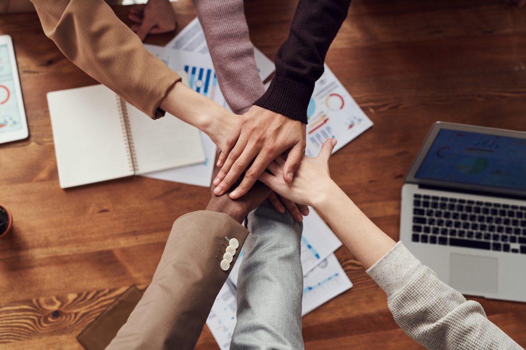 Personnes qui se tiennent la main au-dessus d'un bureau