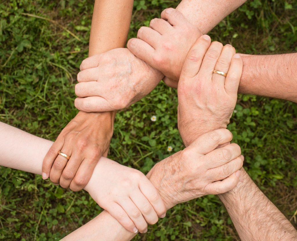 6 personnes qui se tiennent le poignée